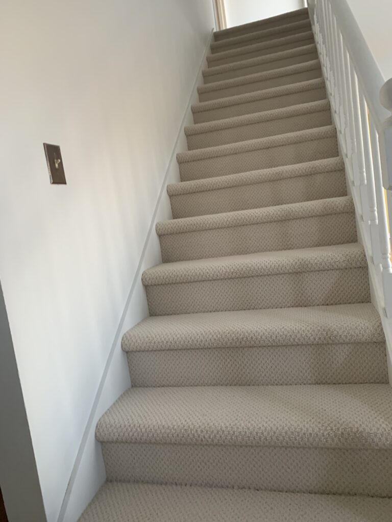 Neutral color carpet on the stairs. Flooring installers.
